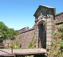 Stone wall with gate and draw bridge.