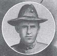 Round portrait of a young man wearing a military hat and jacket.