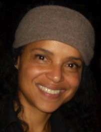 A women with black hair, wearing a brown hat.