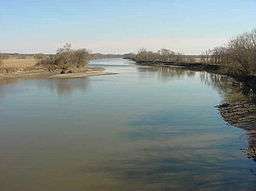 A placid river flows through a prairie landscape.
