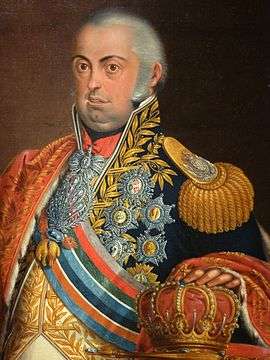 Painting of an overweight man with gray hair, bulging round eyes and a double-chin. He is clothed in a dark blue uniform that is covered by decorations and gaudy decorations. His left hand rests on a crown.