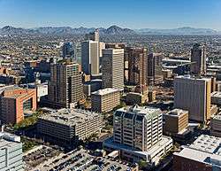 tall buildings of downtown Phoenix, with the mountains to the north in the background, centering on Camelback mountain.