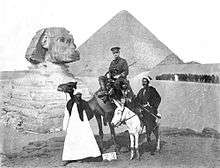 A soldier in uniform sitting on a camel posed in front of the Great Sphinx of Giza