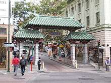 Photo of The Dragon Gate (looks like a small pagoda that you can walk under) as seen in 2008, opening onto Grant Avenue in San Francisco's Chinatown