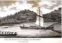 Engraving showing a river with two boats on it. The larger boat is passing through a weir that crosses the entire river. This boat has a mast with two sails. It is being steered by one man at the stern holding a long steering oar. About ten barrels are lashed into its hull. The opposing bank of the river has rock outcroppings. The nearby bank is not visible.