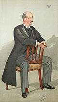 A caricature of a bald man with a moustache, wearing morning dress and sitting astride a wooden chair, a smile on his face and a cigar in his hand.