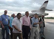 Kirchner and a group of people walking away from a plane