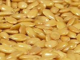 A close-up of glistening, golden flax seeds.