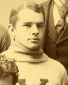 A sepia picture of a young man in a sweater with a "Y"