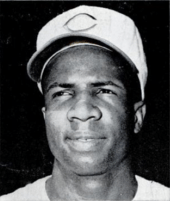 A head shot of an African-American man with a white baseball cap with a red "C" in the center.
