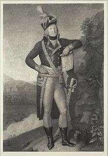 Black and white print of a man standing and holding a map in his hand. He wears a French officer's military uniform of the 1790s with bicorne hat, dark coat with lace trim and a long tail, tight white breeches, black boots and a sword.