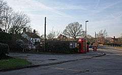 Road junction with red telephone box and white-painted public house