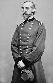 Photo of a balding and bearded George Meade in a military uniform. The somewhat thin figure is standing while holding a kepi.