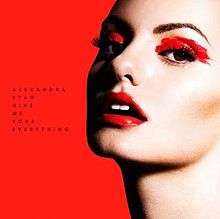 The cover for "Give Me Your Everything" features Stan standing in front of a red backdrop. She wears red make-up, with the name of the song being shown on her right.