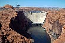 Frontal view of a concrete dam and a river canyon.