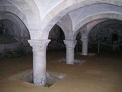 Interior view of a chamber, with arches supporting the pillars holding up the roof.
