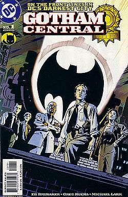 Five police officers on a rooftoop, standing in front of a the 'Bat signal' searchlight