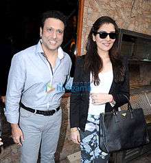 A smiling Govinda and his daughter, wearing sunglasses
