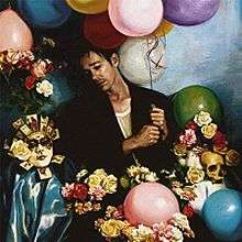 The album is with a man surrounded by a skull, mask, and roses while holding a bunch of different colored balloons