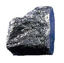 A shiny grey-black cuboid nugget with a rough surface.