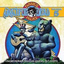 A skeleton dressed as Uncle Sam plays a guitar. A bear seated nearby, and a crow sitting on the bear's shoulder, listen. A basketball lies in the grass.