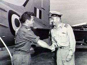 Two men in military uniforms shaking hands