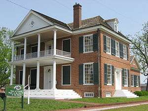 Large red brick home with two-story columned white porch