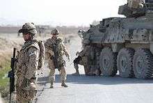 Canadian Grenadier Guards in Kandahar Province standing by road with armoured car