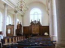 Church interior with stone columns, barrel vault, arched window