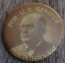 A late 19th century celluloid political button in black and white; on the top "For U.S. Senator" and at bottom "M.A. Hanna", framing an image of the candidate