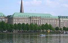 A multi-storey office building in front of a waterbody.