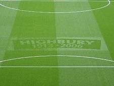 A photograph of a green football turf, with the words Highbury, 1913–2006 etched in the middle.