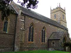 Stone building with arched windows and square tower.