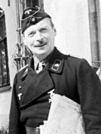 A smiling man in uniform holding s sheaf of documents