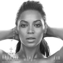 The cover of the album "I Am... Sasha Fierce" features the face of Beyoncé. She is looking directly to the camera while she keeps her hands behind her head. Her hair is combed with a ponytail, and she wears a bracelet on her right wrist. At the lower left corner her first name is written in capital silver letters, while "I Am..." is written with the same pattern at the right corner.
