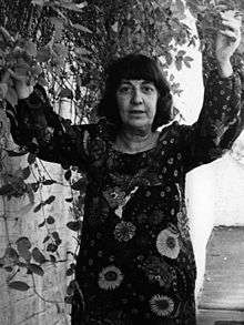 Ida Kar a few months before her death, in a flowery dress with her arms raised