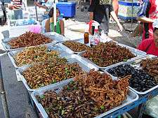 Large baskets of insects and scorpions at a market.