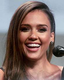 A portrait shot of Jessica Alba, an attractive women with long brown hair, smiling