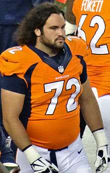 Photograph of Moffitt on a football sideline wearing a #72 Denver Broncos uniform