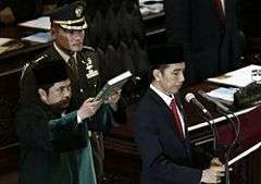 Joko Widodo reciting his presidential oath under a copy of the Quran