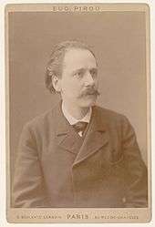 Middle-aged man, receding hair, moustached, looking at camera
