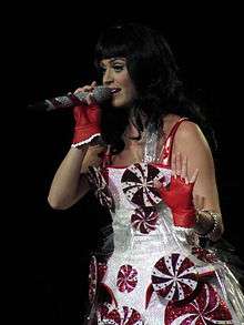 Perry performing in a dress decorated with peppermint swirls