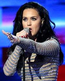 Katy Perry in performance, with her left arm raised