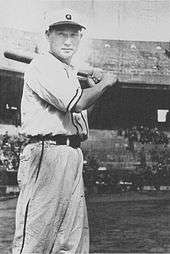 Tetsuharu Kawakami wearing a white old-style baseball uniform and holding a baseball bat over his shoulder