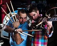 Photograph of two men posing with instruments.