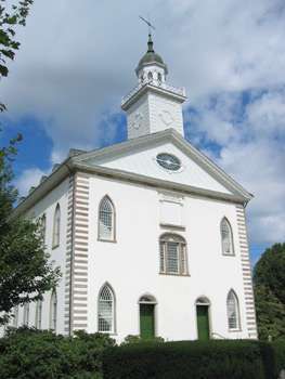 A white two-story building with a steeple