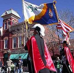 A photograph of a Knights of Columbus Color Corps marching in a Parade.