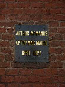 Plaque on a brick wall with inscription: Arthur MacManus/Артур Макманус, 1889–1927