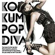 A woman, dressed in a black dress with black-coloured accessories, leaning backwards, holding her hand against her mouth. The text "Koda Kumi", "Pop Diva", and "You know I'm top diva, most beautiful, powerful, and talented girl on the planet... Are you ready for me?? Let's GO!!" are imprinted on the left side of the cover.