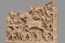 stone relief sculpture of horse and men